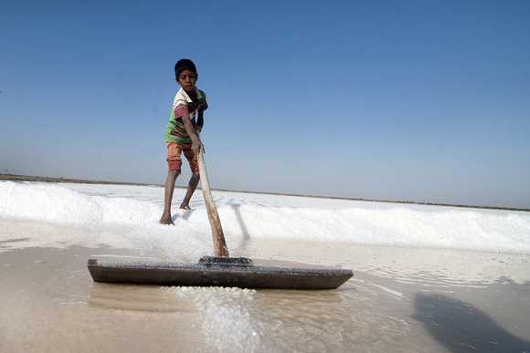 Surath, 12, is working in his family’s salt pans