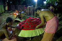 Workers preparing the god's costume using richly coloured fabrics