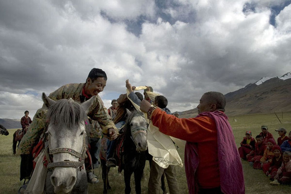 A Changpa rider is being worn the kaata, the ceremonial silk scarf by a high monk.