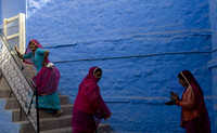 The women are almost always dressed in bright colours  which offsets the monochromatic blue backdrop
