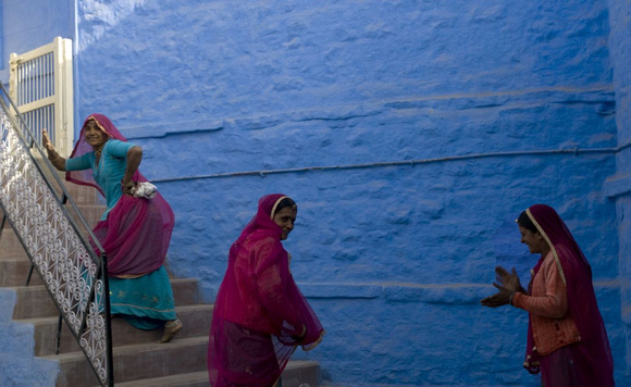 The women are almost always dressed in bright colours  which offsets the monochromatic blue backdrop