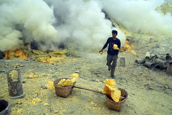 A miner runs with a block of sulphur to fill his basket