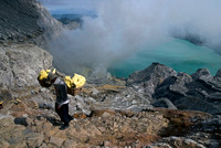 Miners carry heavy loads of sulphur weighing over 80 kg up a steep path