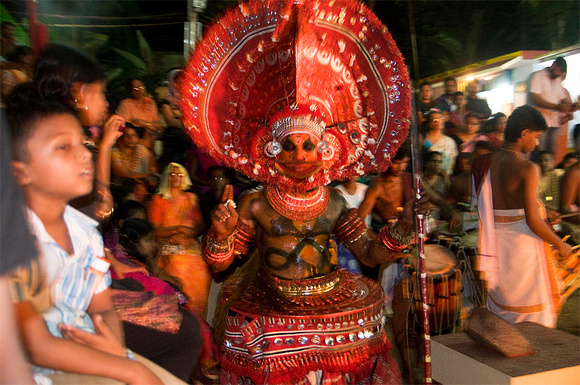 An oracle struts through the crowd, chanting blessings as the devotees gather around him