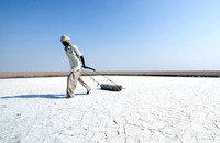 Davalram, 64, leveling the salt pan his family has worked